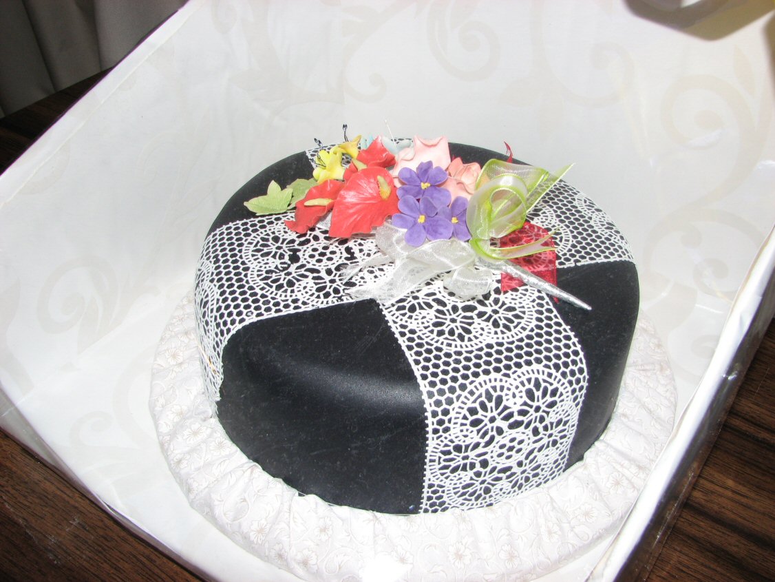 Black celebration cake with white edible lace